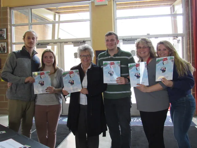 Julie Prantera with five adults, each holding Tommy Tablet at Niagara Falls.